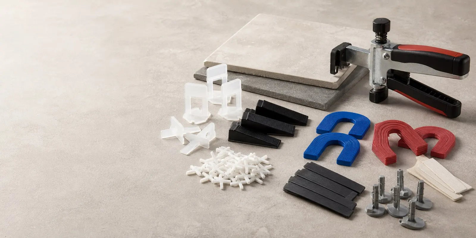 Tile spacers, leveling clips, wedges, and shims arranged on a workbench.